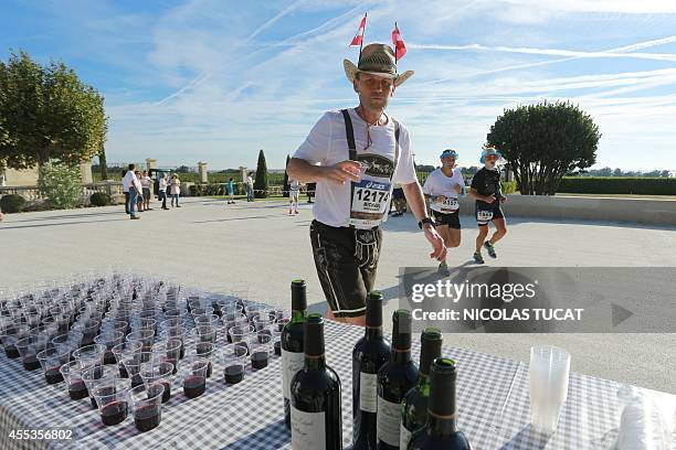 Runner stops of a wine break in the courtyard of Chateau Montrose, near Pauillac, during the 30th Marathon du Medoc, a 26-mile circuit in the Medoc...