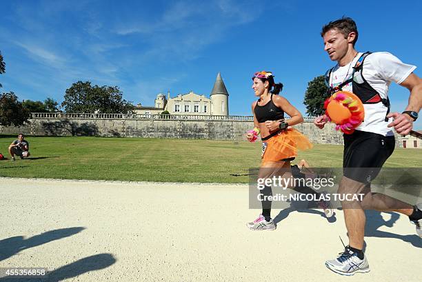 Athletes run past Chateau Lafite Rotschild, near Pauillac, during the 30th Marathon du Medoc, a 26-mile circuit in the Medoc wine region near...