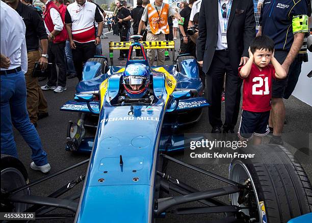 Young Chinese fan puts his hands over his ears as Prost Racing Driver Nic Prost sits in his car on the grid before the inaugral FIA Formula E Beijing...