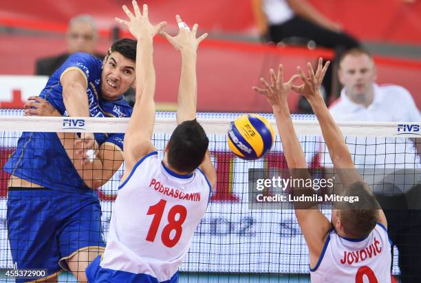 France's Nicolas Le Goff attacks against Serbia's Marko Podrascanin and Nikola Jovovic during the FIVB World Championships match between Serbia and...