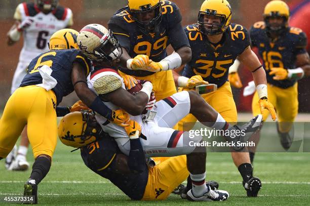 Tight end Andrew Isaacs of the Maryland Terrapins is hit by linebacker Isaiah Bruce of the West Virginia Mountaineers and teammates in the second...