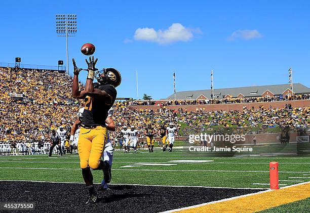 Wide receiver Bud Sasser of the Missouri Tigers makes a catch in the end zone for a touchdown as defensive back Jordan Ozerities of the UCF Knights...