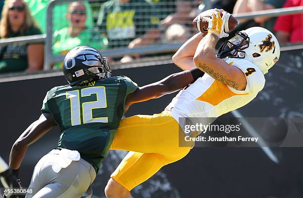 Tanner Gentry of the Wyoming Cowboys catches a touchdown pass against Chris Seisay of the Oregon Ducks at Autzen Stadium on September 13, 2014 in...