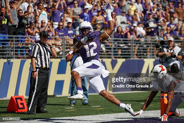 Running back Dwayne Washington of the Washington Huskies rushes for a touchdown against defensive back Eaton Spence of the Illinois Fighting Illini...