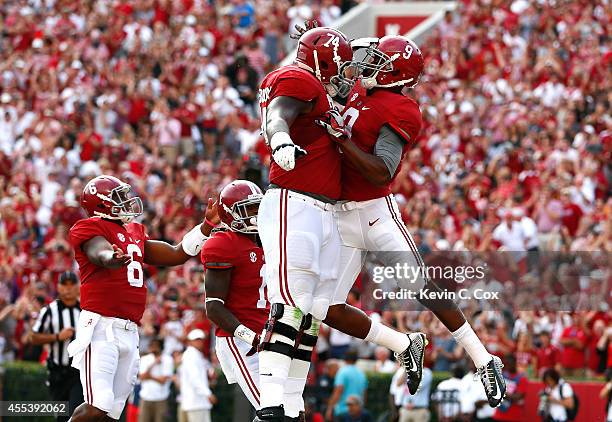 Amari Cooper of the Alabama Crimson Tide celebrates scoring a touchdown against Southern Miss Golden Eagles with Cam Robinson of the Alabama Crimson...