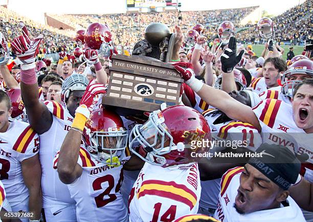 Members of the Iowa State Cyclones celebrate with the Cy-Hawk trophy after defeating the Iowa Hawkeyes 20-17, on September 13, 2014 at Kinnick...