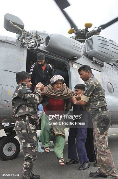 Indian Army soldiers help an elderly woman alight from an IAF helicopter during rescue and relief operations following flooding in Srinagar. The...