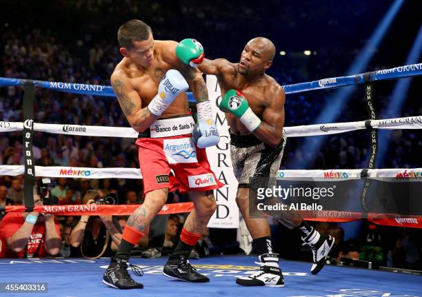 Floyd Mayweather Jr. Throws a right to the face of Marcos Maidana during their WBC/WBA welterweight title fight at the MGM Grand Garden Arena on...