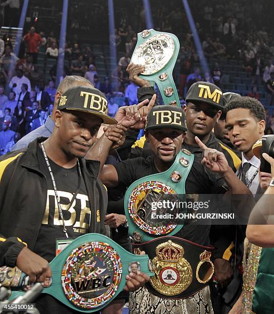 Floyd Mayweather Jr. Of the US poses with his belts after beating Marcos Maidana of Argentina on September 13, 2014 at The MGM Grand, Las Vegas....