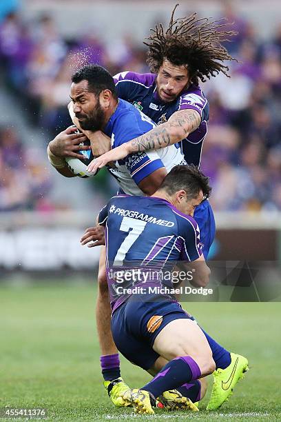 Tony Williams of the Bulldogs is tackled by Cooper Cronk and Kevin Proctor of the Storm during the NRL 2nd Elimination Final match between the...