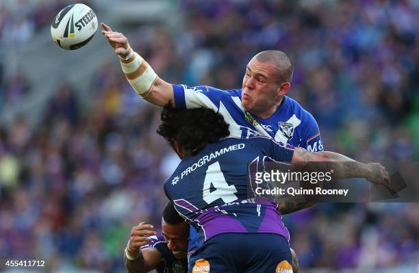 David Klemmer of the Bulldogs passes the ball whilst being tackled by Mahe Fonua of the Storm during the NRL 2nd Elimination Final match between the...