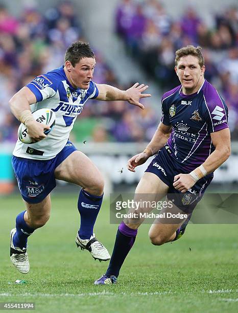 Josh Jackson of the Bulldogs runs with the ball away from Ryan Hoffman of the Storm during the NRL 2nd Elimination Final match between the Melbourne...