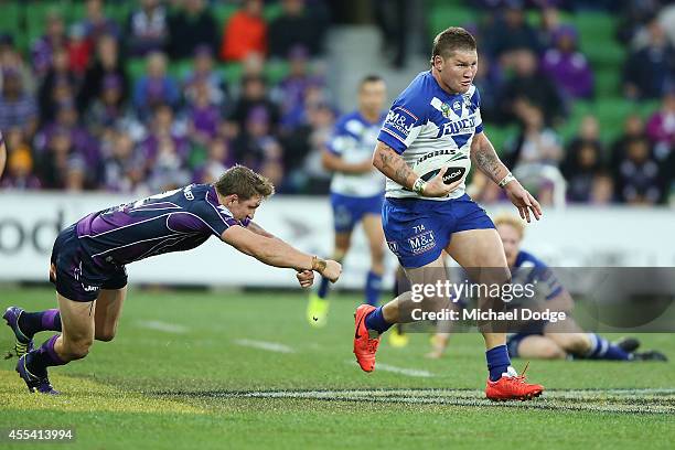 Greg Eastwood of the Bulldogs runs away from Ryan Hoffman of the Storm during the NRL 2nd Elimination Final match between the Melbourne Storm and the...