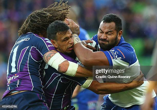 Tony Williams of the Bulldogs is tackled by Kevin Proctor and Will Chambers of the Storm during the NRL 2nd Elimination Final match between the...