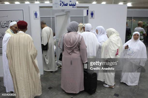 Muslim prospective pilgrims wait in front of a praying room before their flight to the Muslim Holy Land at International Carthage Airport in Tunis,...