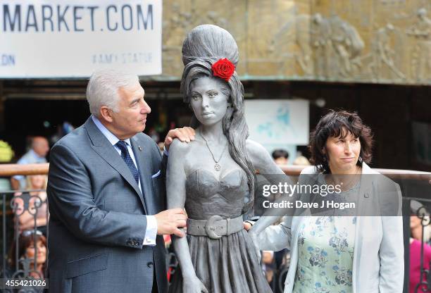 Mitch Winehouse and Janis Winehouse pose as a statue of the late Amy Winehouse is unveiled in Camden Town on September 14, 2014 in London, England.