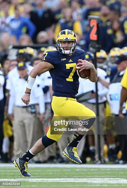 Quarterback Shane Morris of the University of Michigan runs for a first down during the fourth quarter of the game against the Miami University...