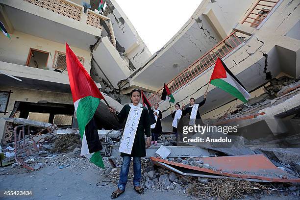 Students hold a Palestinian flag as they listen to Palestinian deputy minister of education Ziyad Sabid's speech on the first day of the new school...