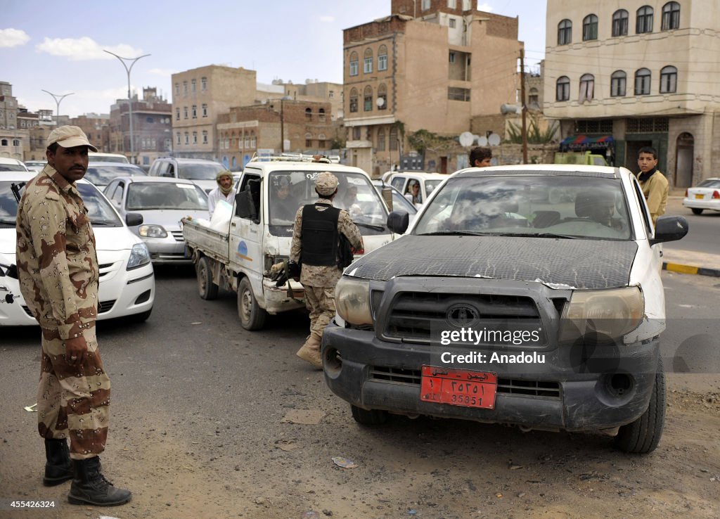Yemeni security forces check the cars at the entrance to Sanaa