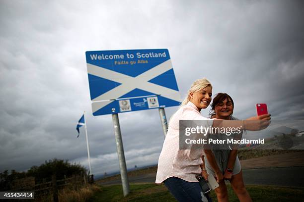 Two returning Scottish women take a photograph of themselves on the border with England on September 14, 2014 in Carter Bar, Scotland. The latest...
