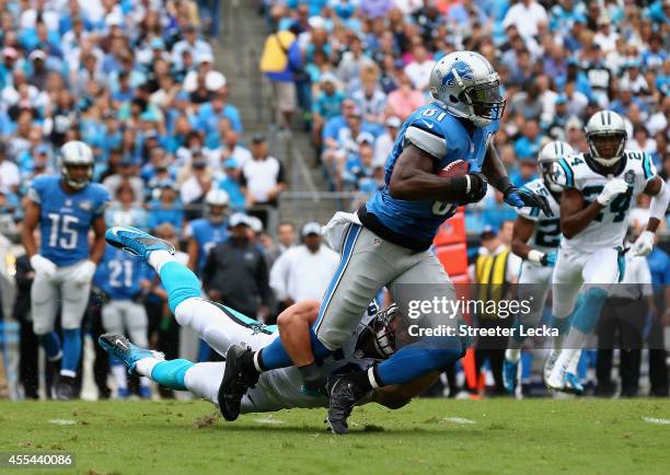 Luke Kuechly of the Carolina Panthers tackles Calvin Johnson of the Detroit Lions during the game at Bank of America Stadium on September 14, 2014 in...