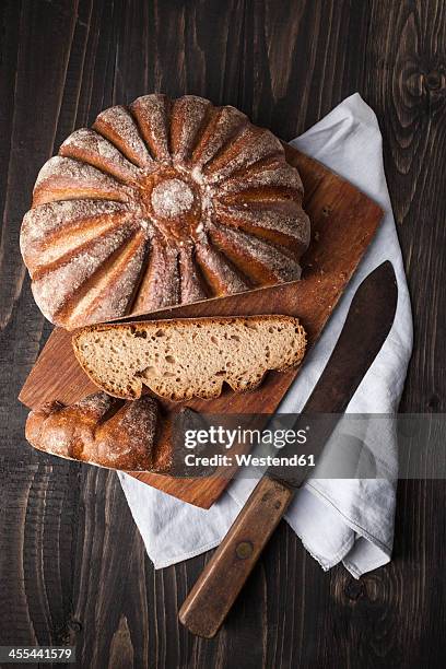 fresh baked bread on chopping board, close up - bread knife stockfoto's en -beelden