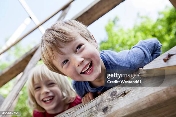 germany, north rhine westphalia, cologne, boys playing in playground, smiling - playground stock-fotos und bilder