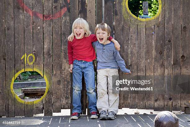 germany, north rhine westphalia, cologne, boys playing in playground, smiling - boys sport pants stock pictures, royalty-free photos & images