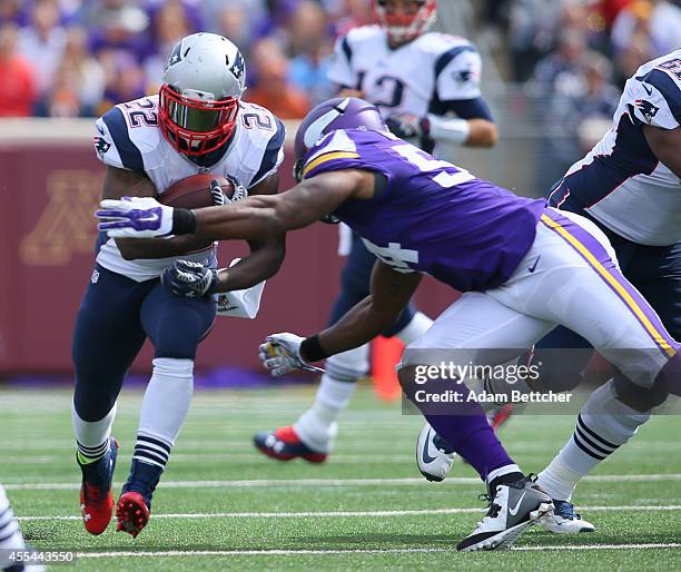 Stevan Ridley of the New England Patriots carries the ball for a gain in the second quarter while Jasper Brinkley of the Minnesota Vikings makes the...