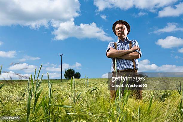 germany, bavaria, farmer standing with arms crossed in field - farmer arms crossed stock pictures, royalty-free photos & images