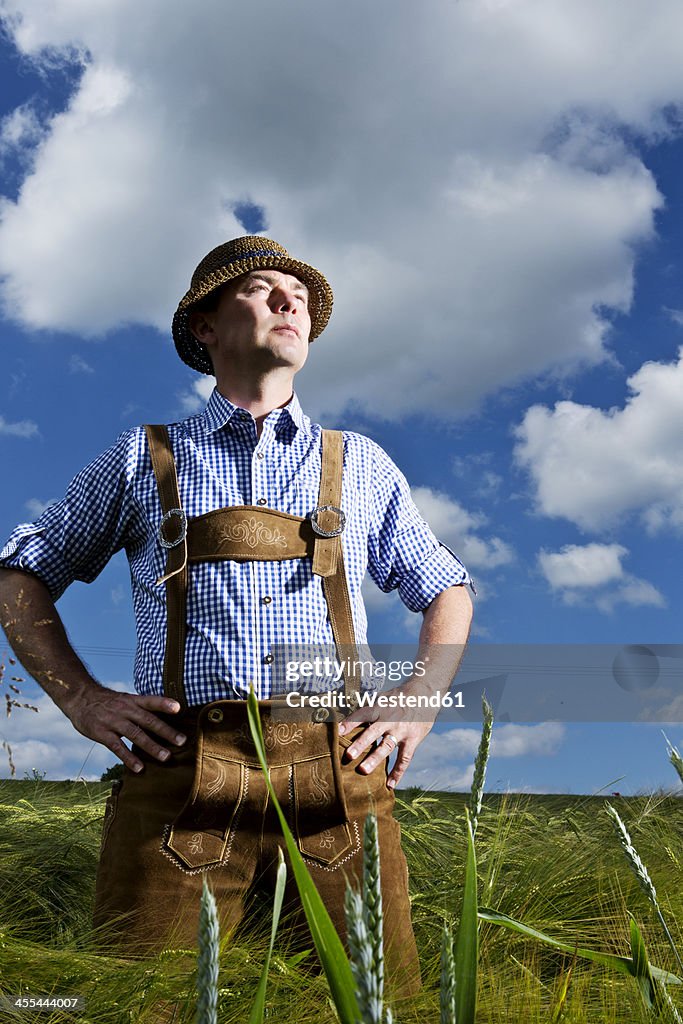 Germany, Bavaria, Farmer standing in field and looking away