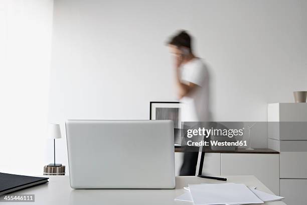 germany, north rhine westphalia, businessman talking on mobile phone - bewegungsunschärfe büro stock-fotos und bilder