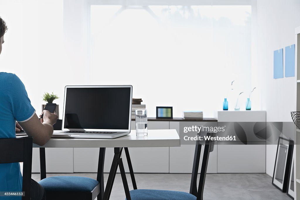 Germany, North Rhine Westphalia, Businessman using mobile phone