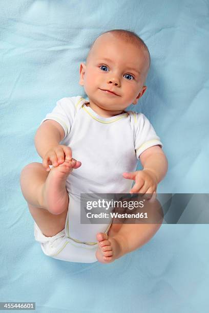 germany, bavaria, portrait of baby boy lying on blanket, smiling - supino foto e immagini stock