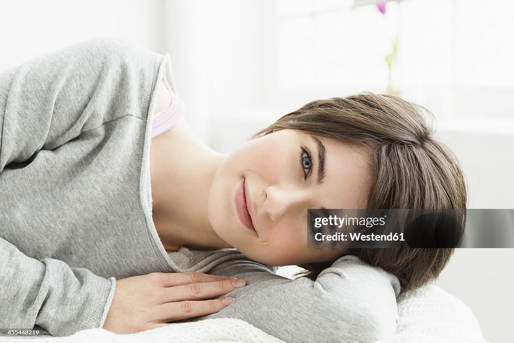 Germany, Bavaria, Munich, Portrait of young woman relaxing, smiling