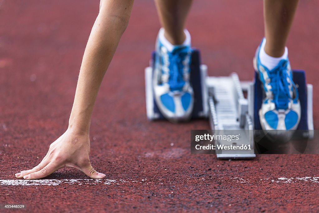 Germany, Young woman running from sprint start
