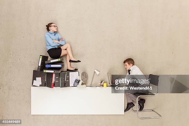 business boy using laptop while girl sitting on stack of files - kid chef stock-fotos und bilder