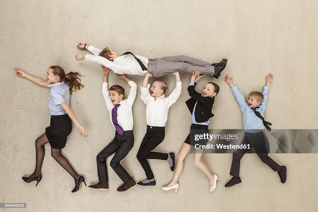 Business kids carrying boy in office