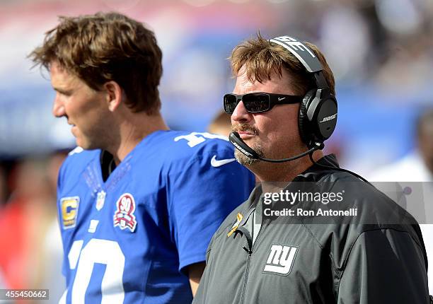 Offensive coordinator Ben McAdoo and quarterback Eli Manning of the New York Giants look on from the sideline against the Arizona Cardinals during a...