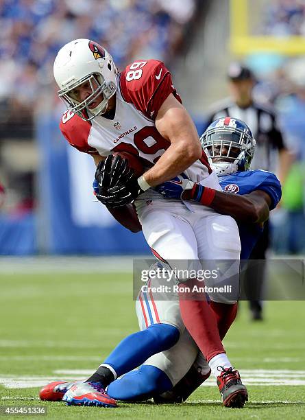 Tight end John Carlson of the Arizona Cardinals is tackled by strong safety Antrel Rolle of the New York Giants during a game at MetLife Stadium on...