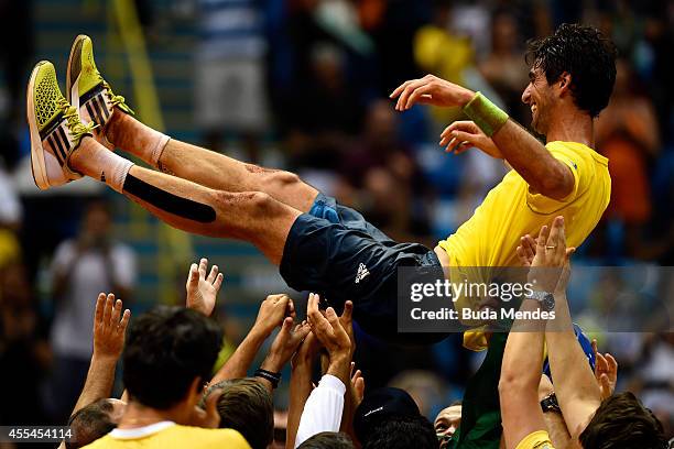 Thomaz Bellucci of Brazil is carried by teammates after winning his play-off singles match against Roberto Bautista Agut of Spain on the World Group...