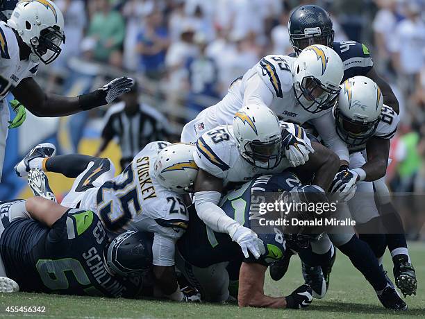 Tight end Luke Willson of the Seattle Seahawks is tackled by defensive back Darrell Stuckey, inside linebacker Kavell Conner and inside linebacker...