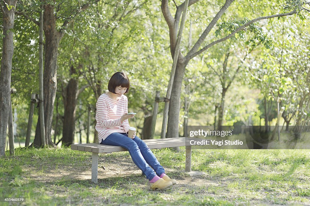 Woman using a Smart phone in the green
