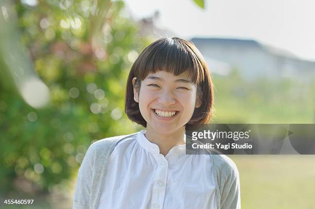 smiling woman in the green - japanischer abstammung stock-fotos und bilder