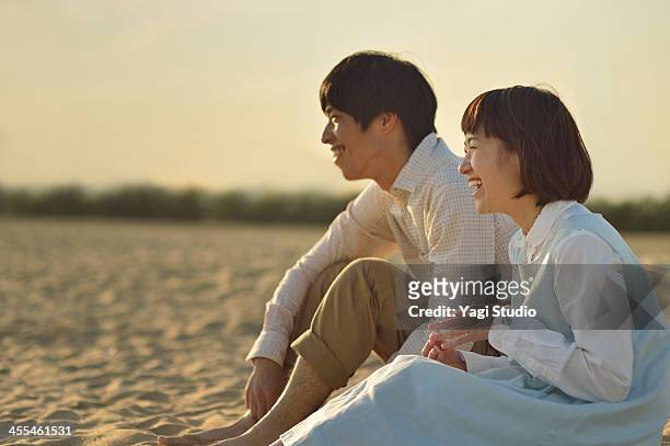 couple enjoying day out at the beach - japanese couple beach stock pictures, royalty-free photos & images