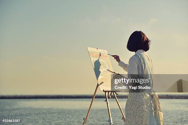 woman drawing the oil painting on the beach - easel imagens e fotografias de stock