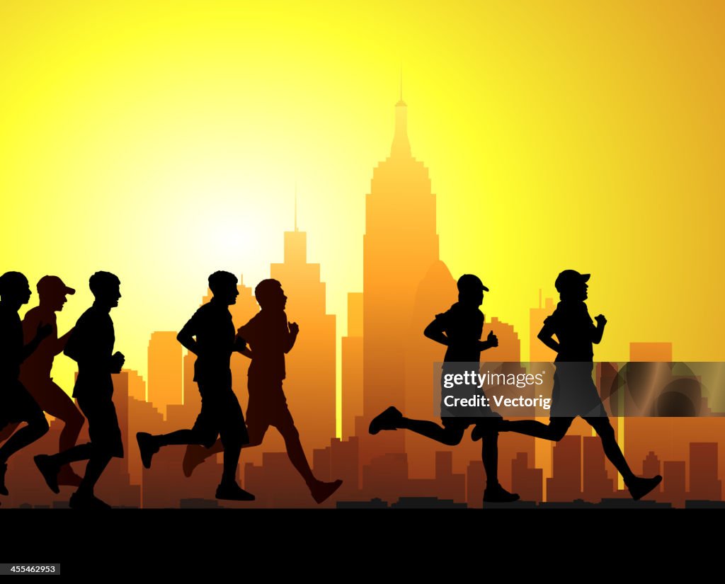 Silhouette of race runners in front of sunset lit cityscape