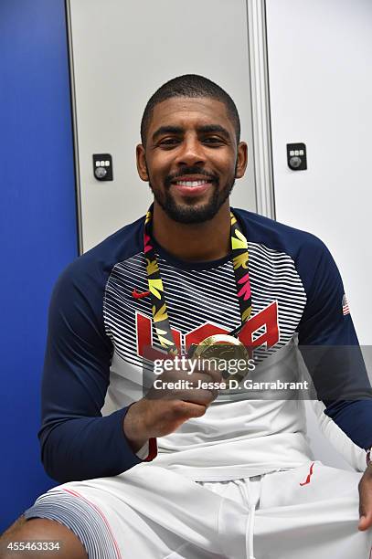 Kyrie Irving of the USA Men's National Team poses for a photo with the gold medal in the locker room after defeating the Serbia National Team during...