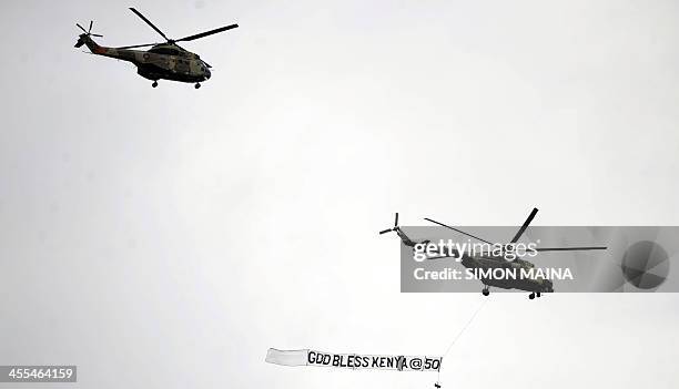Kenyan military helicopters fly past the presidential dias at the Kasarani stadium dance in Nairobi on December 12, 2013 during Kenya's celebrations...
