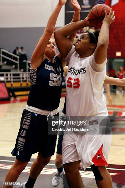 Bernadette Fong of the Cal State Northridge Matadors shoots against Ingrida Strikas of the Utah State Aggies in the Consolation Game of the Radisson...
